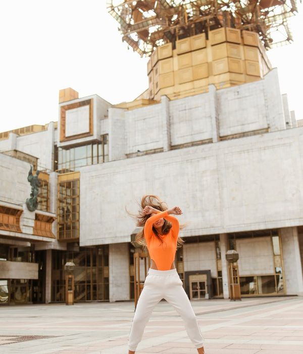 Person feeling energized and stretching in a bright, open space.